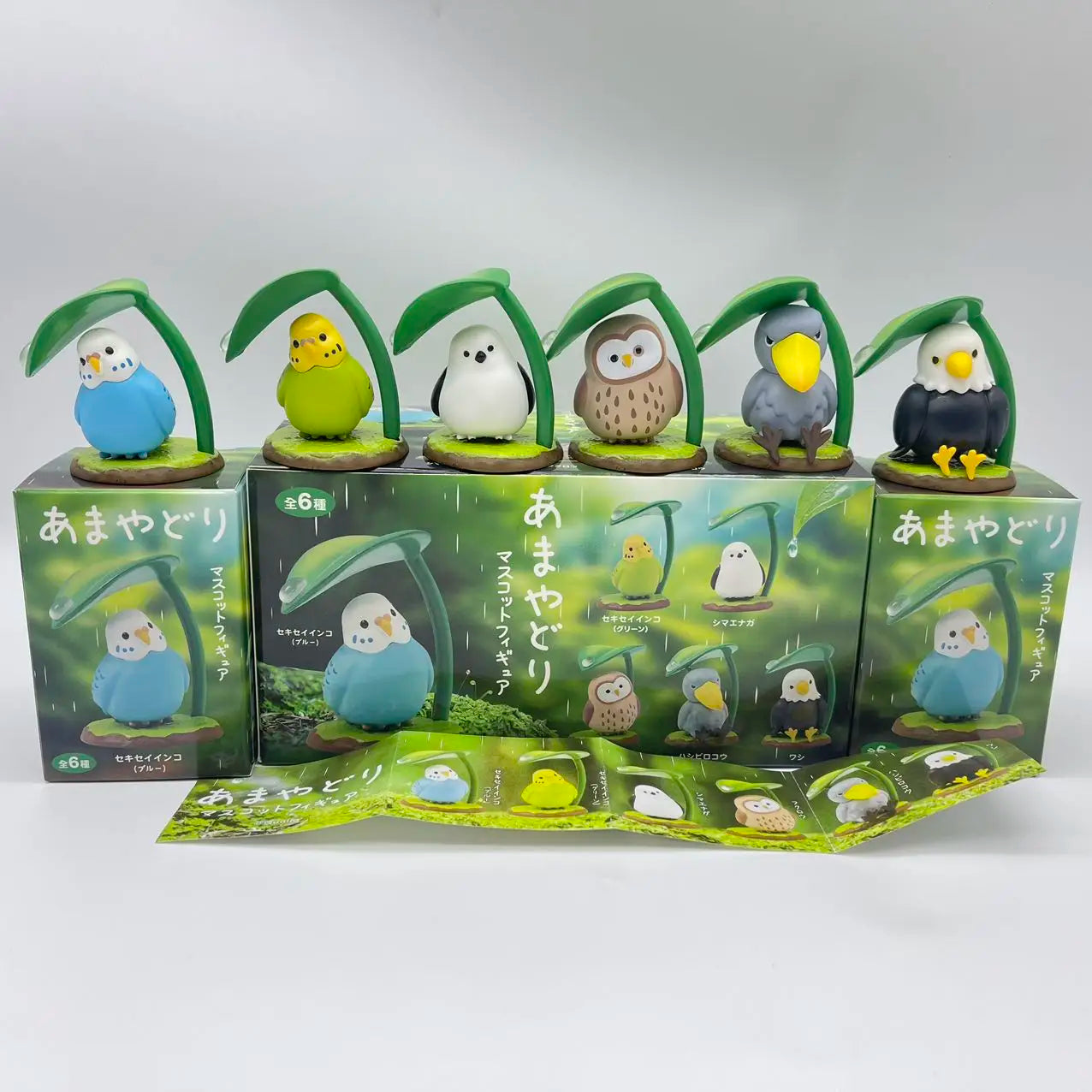 Caja sorpresa con figuras kawaii de pajaros ocultos debajo de hojas, estilo japonés — Don Gachapón